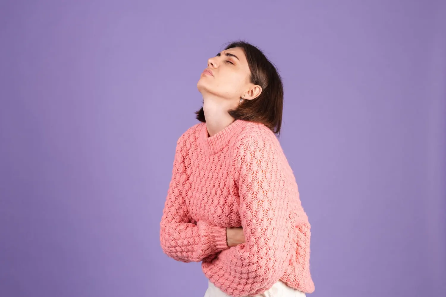 young-brunette-pink-sweater-isolated-purple-wall